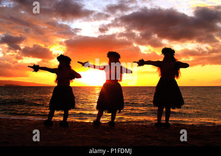 Tre danzatori di hula al tramonto a Palauea Beach, Maui, Hawaii. Foto Stock