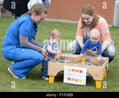 Team Mildenhall bambini visitano la foglia sensoriale area di gioco durante un festival di autunno ott. 28, 2016 al bambino un centro di sviluppo sulla RAF Mildenhall, Inghilterra. I bambini hanno preso parte alla parata poi ha avuto la possibilità di giocare con la vernice e foglie. (U.S. Air Force foto da Gina Randall) Foto Stock