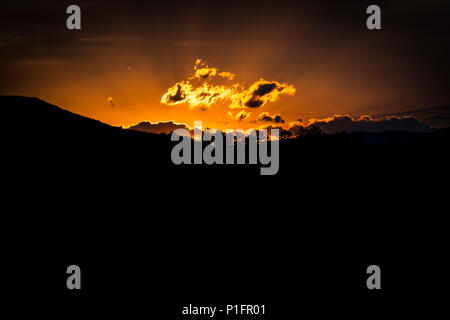 Inquadratura orizzontale di una brillante alba di montagna con un nero in primo piano e copia dello spazio. Foto Stock