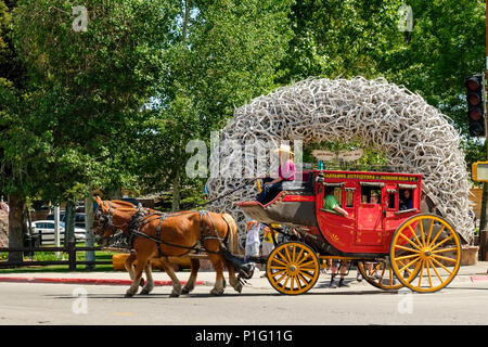 Cavallo e Carrozza tipica del vecchio West americano porta i turisti in Jackson Wyoming di fronte iconico ingresso parco arco di corna. Foto Stock