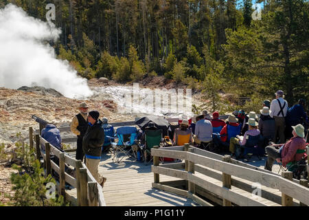 Gruppo di turisti in attesa di Steamboat Geyser a scatenarsi nel parco nazionale di Yellowstone Foto Stock