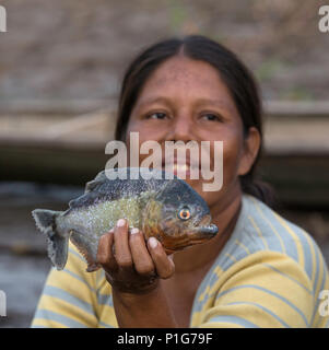 La donna che mostra la sua cattura di pesce a Atun Pozas, Superiore Amazzonia, Loreto, Perù Foto Stock