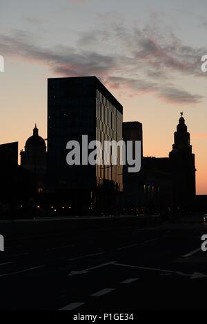 Tramonto sagome di edifici sul lungomare di Liverpool, in Inghilterra, Regno Unito Foto Stock