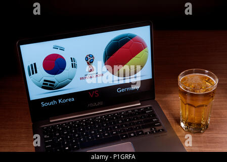 La Corea del Sud e il tedesco bandiere visto insieme con il russo 2018 World Cup logo visualizzato su un portatile accanto a un bicchiere di birra. Questo gioco appartiene alla prima partita dal Gruppo F e verrà giocato a Kazan, Russia. Foto Stock