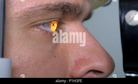 Giovane uomo controlla gli occhi sulle attrezzature moderne nel centro medico Foto Stock