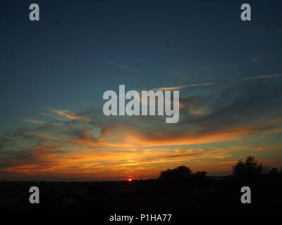 Sunset, Bedfordshire, Regno Unito, vicino a Milton Keynes, il blu e il cielo arancione Foto Stock