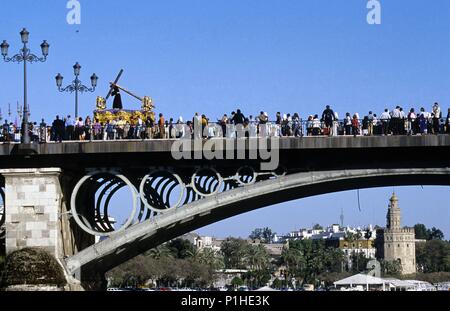 Spagna - Andalusia - La Vega (distretto di Sevilla) - Siviglia. semana santa (viernes), Cofradía de La " O " a la ida por el Puente de Triana, Torre del Oro. Foto Stock