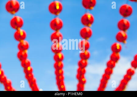 Sfocare lo sfondo di molte righe rosso cinese lanterne di carta nella parte anteriore del cielo blu Foto Stock