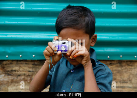 Un rifugiato Rohingya ragazzo con la sua fotocamera giocattolo a Kutupalong Refugee Camp a Ukhiya In Cox bazar, Bangladesh Foto Stock