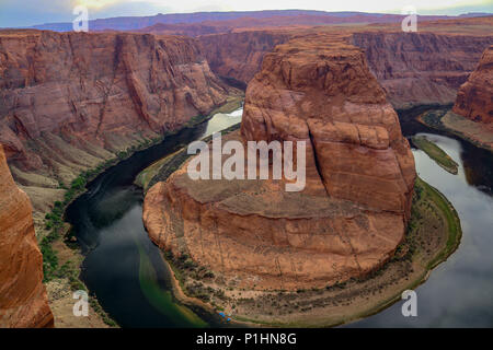 Tramonto sulla famosa curva a ferro di cavallo in Utah e Arizona. Il bellissimo fiume Colorado scolpito questa a forma di ferro di cavallo in pietra arenaria Arancione riflettente, rosso, verde Foto Stock