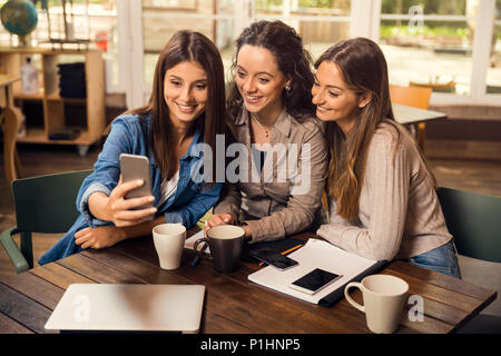 Gruppi di amici femmina facendo una selfie durante una pausa sugli studi Foto Stock