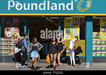 Le persone e gli amanti dello shopping a piedi passato lo sconto negozio Poundland su Camden High Street a nord di Londra. Poundland ha fatto bene durante l'austerità. Foto Stock