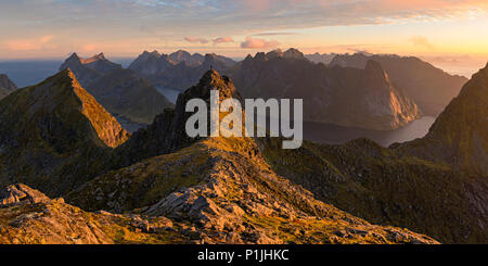 Panorama di montagna con alpenglow e escursionista nella luce del mattino, Munken, Moskenesoy, Lofoten, Norvegia Foto Stock