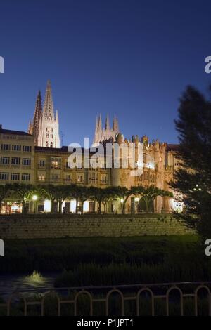 Ribera del río Arlanzón con Arco de Santa María y Catedral (nocturna). Foto Stock