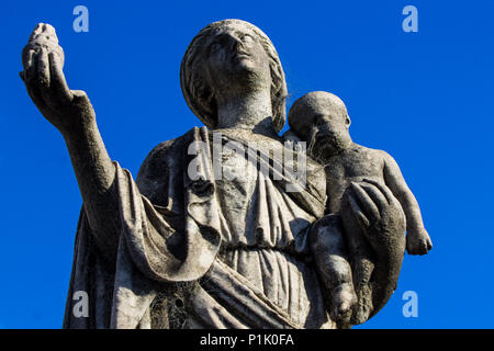 Un paziente madre detiene il suo bambino in una mano e una candela in altri presso il Cimitero di Recoleta in Buenos Aires, Argentina. Foto Stock