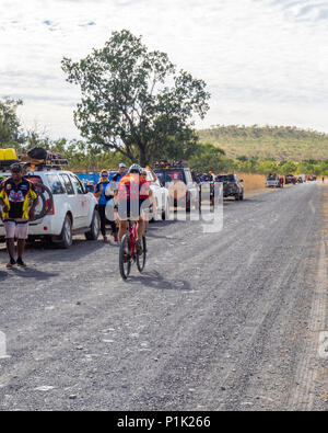 Gibb Challenge 2018 ciclista in jersey e bib passato di equitazione convoglio di 4 ruote motrici di veicoli di supporto su strada sterrata Gibb River Road WA Kimberley Australia Foto Stock