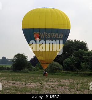 Una mongolfiera ha appena sbarcati in un campo a fianco del Leeds e Liverpool canal e Crabtree Lane vicino a Wigan Greater Manchester West Lancashire al mattino. Foto Stock