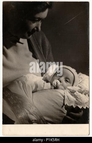 LA REPUBBLICA SOCIALISTA CECOSLOVACCA - CIRCA 1960s: Foto d'epoca mostra la madre culle il suo bambino. Foto antica in bianco e nero.1960s. Foto Stock