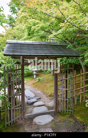 Un cancello di legno e Recinto di bambù in un giardino giapponese. Foto Stock