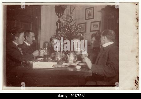 GERMANIA - CIRCA 1940s: Vintage foto mostra la famiglia si siede al tavolo durante il periodo di Natale. Nella camera c'è un albero di Natale. 1940s Foto Stock