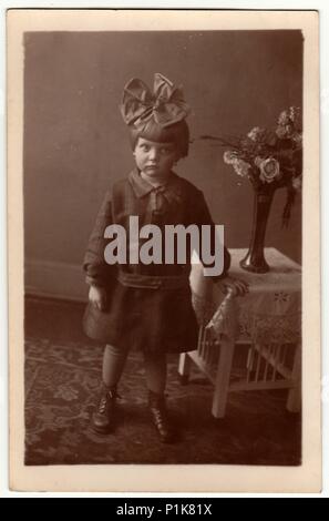 AMBURGO, GERMANIA - CIRCA 1930s: Foto d'epoca mostra una bambina indossa il nastro di capelli, posa in ambienti interni. Fotografia in bianco e nero da studio. 1930s Foto Stock