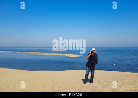 Uomo in piedi sulla duna di Pilat di scattare una foto, La Teste de Buch, Arachon, Nouvelle-Aquitaine, Francia Foto Stock