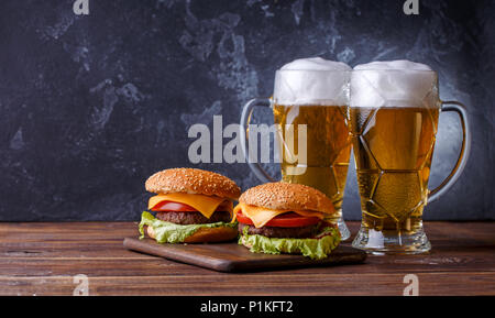 Foto di due hamburger, bicchieri di birra Foto Stock