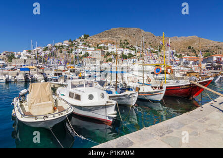 Hydra porto cittadino riempito con piccole imbarcazioni dei pescatori dominato dal cafe lungomare alberato, Hydra, Grecia Foto Stock