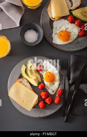 Uovo fritto, avocado, pomodoro per una sana prima colazione Foto Stock