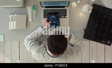 Vista superiore dell'uomo utilizzando tablet pc contro interfaccia medico a raggi x Foto Stock