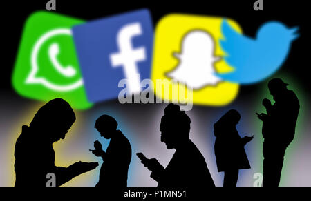 Sagome di un gruppo di persone che si collegano socialmente online utilizzando applicazioni di social media dei dispositivi mobili. Il controllo dei mezzi di comunicazione sociale. Foto Stock