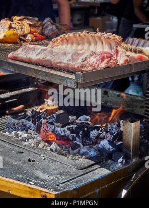 Costine di maiale su un barbecue di carbone in una stalla di una Street Food Fair. Foto Stock