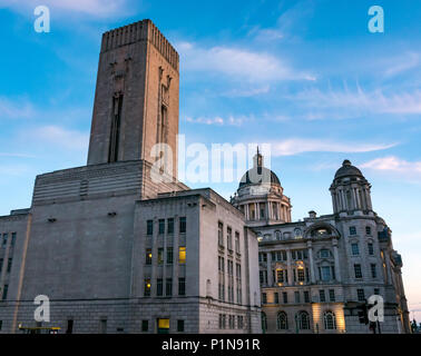 Liverpool Waterfront, Liverpool, in Inghilterra, Regno Unito, 12 giugno 2018. Regno Unito: Meteo tramonto sopra la zona portuale di Liverpool. Gli ornati Art Deco storico Georges Dock dell'albero di ventilazione e il porto di Liverpool edifici illuminati fino al crepuscolo e fare un contrasto stridente con la bassa luce al tramonto Foto Stock