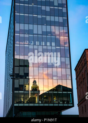 Liverpool Waterfront, Liverpool, in Inghilterra, Regno Unito, 12 giugno 2018. Regno Unito: Meteo tramonto sopra la zona portuale di Liverpool. Un moderno edificio di vetro con una riflessione di storico Royal Liverpool building illuminato fino al tramonto rende un contrasto stridente con la bassa luce al tramonto Foto Stock