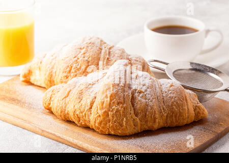 La prima colazione continentale con croissant freschi, succo d'arancia e caffè, focuse selettiva. Foto Stock