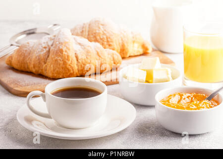 La prima colazione continentale con croissant freschi, succo d'arancia e caffè, focuse selettiva. Foto Stock