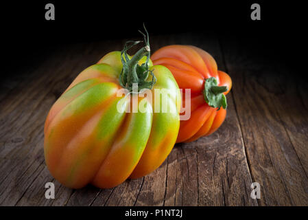 Vista superiore del pomodoro crudo chiamato cuore di bue su sfondo di legno Foto Stock