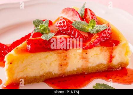 Deliziosa casa cheesecake con fragole su sfondo rosa. Foto Stock