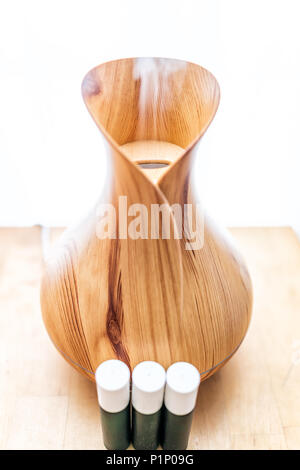 Bambù in legno essenziali diffusore olio closeup, con tre di vetro verde per bottiglie, vapore in stile minimalista moderno minimale vapore di salute Foto Stock