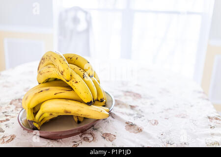 Pila di molti mature spotted a macchie rovinato delle banane gialle sulla tabella piastra piatto panno per tovaglia Foto Stock