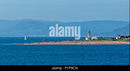 Punto CHANONRY Moray Firth in Scozia con il faro di persone SULLA SPIAGGIA E PONTE KESSOCK INVERNESS IN DISTANZA Foto Stock