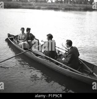 1955, storico, corteggiare?..... due ben vestito giovani coppie di adulti sul Tamigi in una barca rowning a Teddington, Surrey, Inghilterra, Regno Unito. Foto Stock