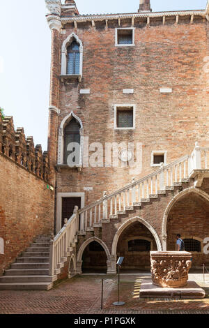 Il cortile della Ca D'Oro Palazzo, Cannaregio, Venezia, Veneto, Italia con il 1427 testa pozzo (pozzo) da Bartolomeo Don e scala a lancetta archi Foto Stock