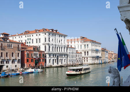 Vista in elevazione del Canal Grande con Ca'angolo della Regina e di Ca' Pesaro, Venezia, Italia con un vaporetto o vaporetto e statua di Lion e bandiere Foto Stock