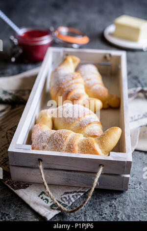 Tradizionali croissant appena sfornati serviti con confettura di lamponi e burro Foto Stock