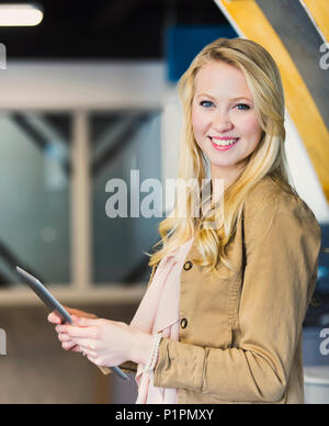 Business ritratto di una giovane e bella la millenaria professional utilizzando tecnologia nel mondo del lavoro; Sherwood Park, Alberta, Canada Foto Stock