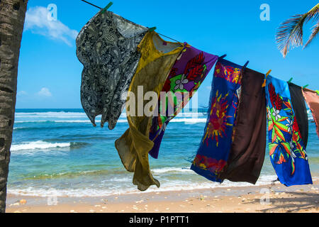 Pittoresca spiaggia asciugamani appeso a un albero in Bathsheba beach; Barbados Foto Stock