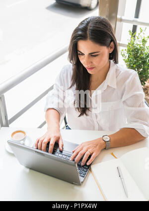 Donna che lavorano sul suo computer in un cafe; Cochabamba Bolivia Foto Stock