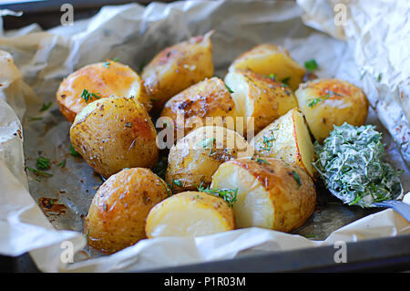 Patate fritte su vassoi da forno con crosta dorata e salsa di aneto Foto Stock