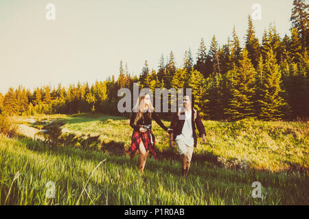 Coppia giovane camminare insieme a fianco di un torrente in un parco della città; Edmonton, Alberta, Canada Foto Stock